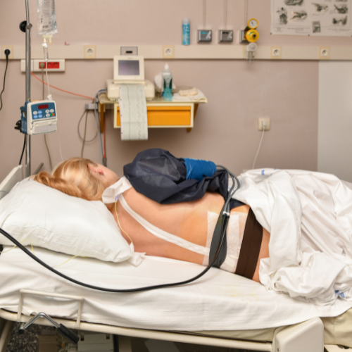 person lying on their side with back facing camera with labor epidural taped up back