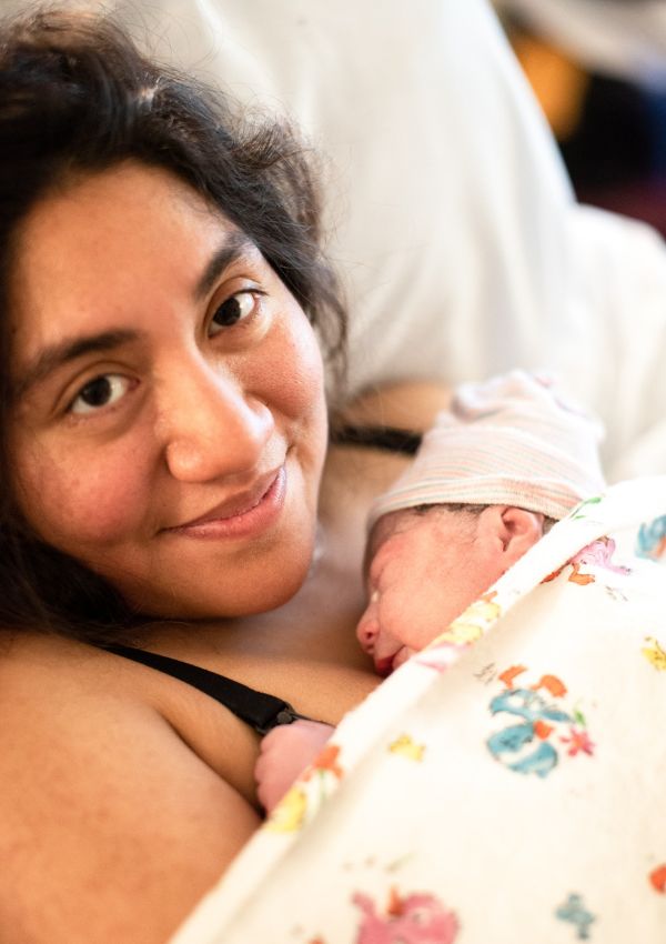mom smiling with newborn after birth